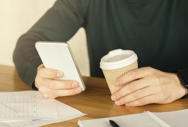 在工作场所室内一边喝咖啡一边使用手机的男子图片下载