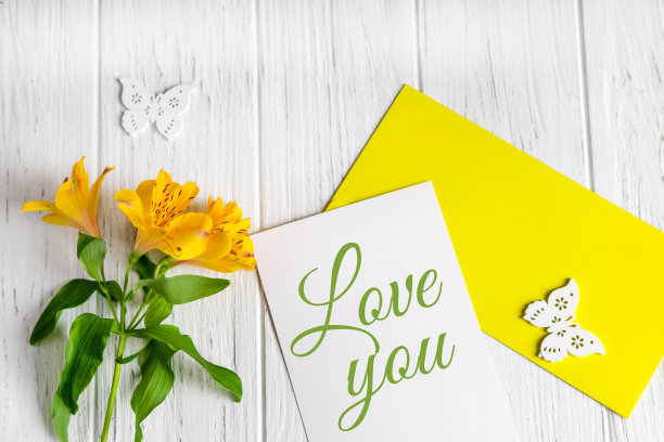 卡片上的题词爱你。黄色的紫花花在浅色的木质背景上。爱的问候。从上面的观点图片下载