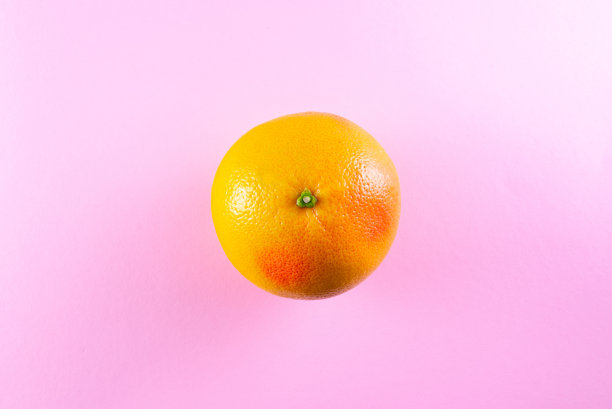 正上方的照片，橙色柚子在粉红色的背景图片下载