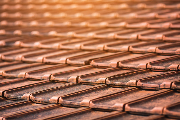 橙色肮脏的陶瓷屋顶瓦的特写。图片下载
