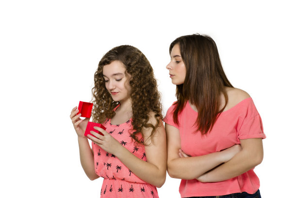 收到礼物的漂亮少女，以及一旁嫉妒的女孩，白色背景图片下载