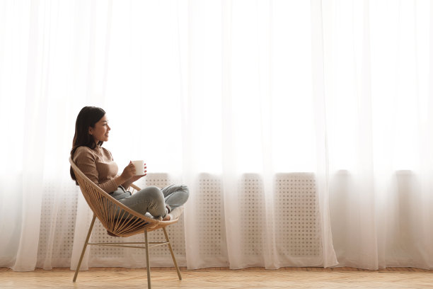 下午茶：坐在现代椅子上放松的女孩图片下载