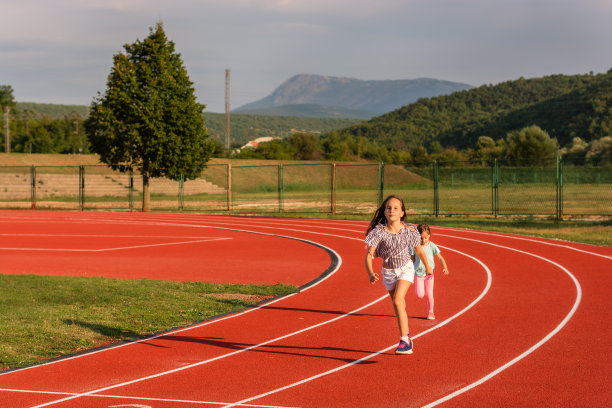 两个小女孩在户外跑道上跑步图片下载