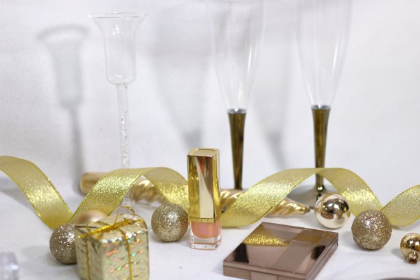 眼影和口红化妆品，香槟玻璃和闪光装饰(白色背景)图片下载