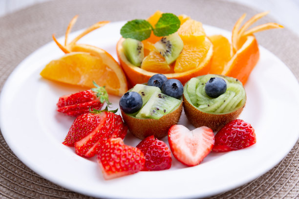 节日的餐桌上摆满了盛在盘子里的美味水果图片下载