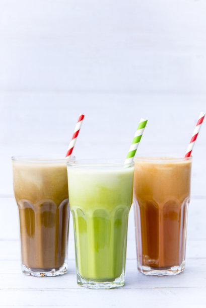 冰牛奶咖啡，绿茶，冰泰国奶茶饮料在高脚杯孤立在白色木桌的背景，选择性的焦点，冷饮如此美味和小吃，拷贝空间。图片下载