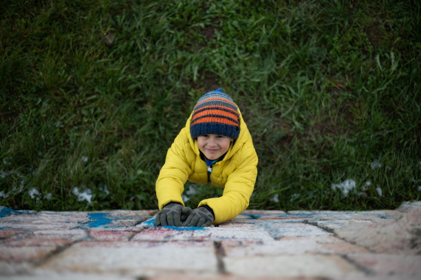 学龄前的男孩站在草地上看着相机上面的库存照片图片下载
