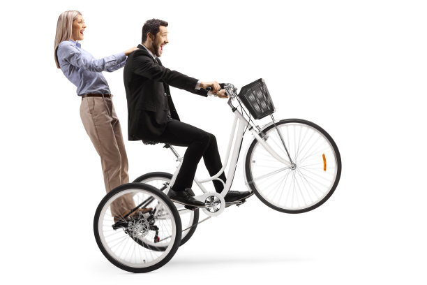 一个男人骑着一个女人骑着前轮翘着的三轮车图片下载