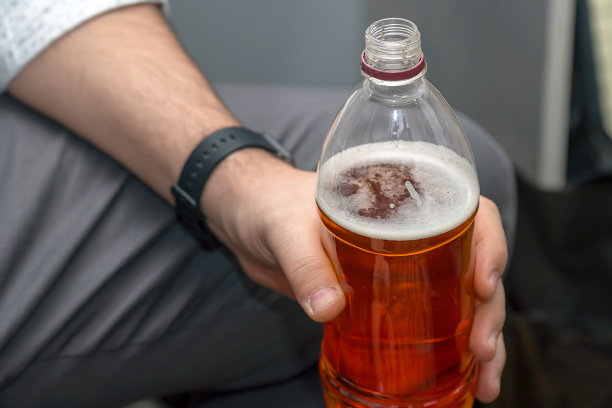 男人手持塑料啤酒瓶图片下载