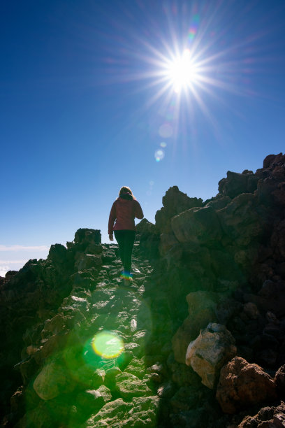 在西班牙加那利群岛的泰德峰岩石山峰上徒步的女子背影照片图片下载
