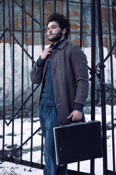 穿着外套，手提箱子的男人图片下载