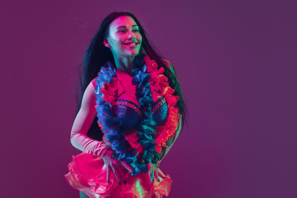 迷人的夏威夷褐发模特在霓虹灯紫色工作室背景图片下载