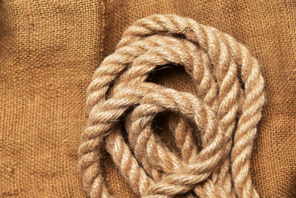 纺织粗麻布背景上的螺旋绳图片下载