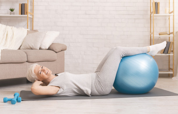 快乐的活跃老年妇女用健身球做运动图片下载