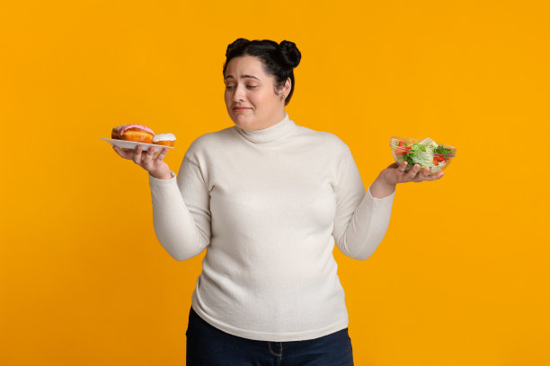 胖女孩在甜甜圈和新鲜蔬菜沙拉之间犹豫不决图片下载