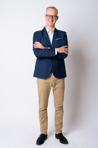 全身拍摄的快乐年轻的金发商人西装微笑与双臂交叉图片下载