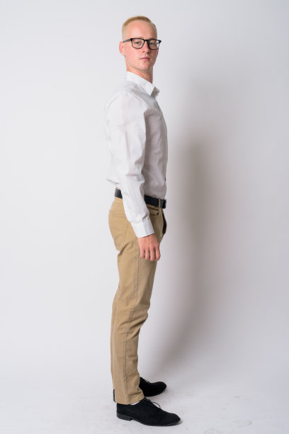 全身拍摄的侧面视图，年轻的金发商人与眼镜看在相机图片下载