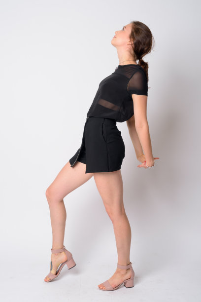年轻美丽的女人伸展手臂的全身拍摄侧面视图图片下载