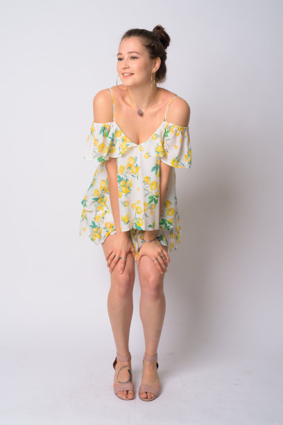 全身照片的快乐年轻美丽的女人思考与双手在膝盖上图片下载