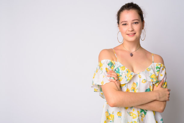 幸福年轻美丽的女人的肖像与双臂交叉微笑图片下载