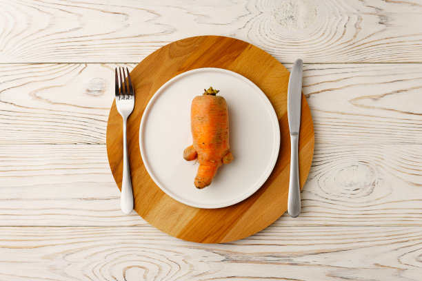 白盘子里丑陋的胡萝卜图片下载