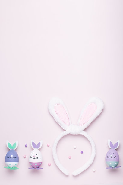 有趣可爱的兔子蛋和兔子耳朵的孩子们在粉色的桌子上，复活节的概念。复活节装饰适合儿童平躺，复制空间图片下载