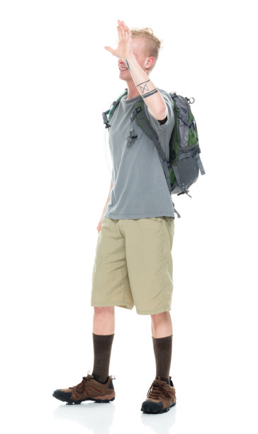 白人年轻男性背包客在白色背景下背着背包和拿着包徒步旅行图片下载