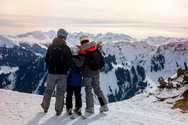 一家人，在阳光明媚的冬日滑雪场滑雪，欣赏风景图片下载