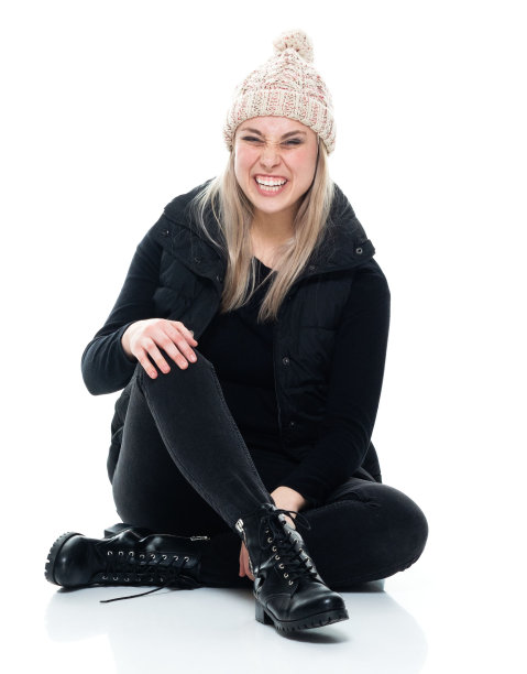 白种年轻女性穿着无袖上衣在白色背景前休息图片下载