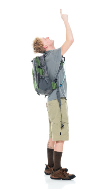 白人男性背包客在白人背景前背着背包和拿着包图片下载