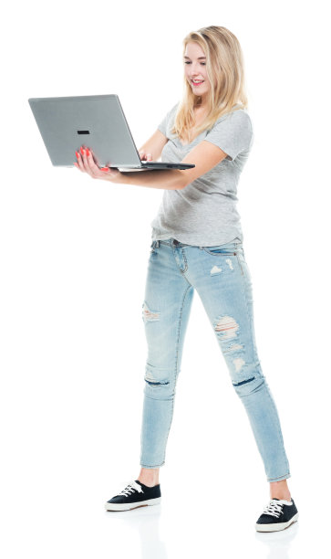 z一代的少女穿着牛仔裤站在白色背景前使用电脑图片下载