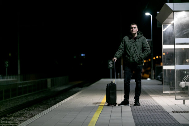 一个男人在火车站带着包旅行。图片下载
