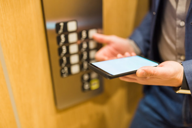近距离的商人使用黑屏智能手机和按电梯按钮。商务办公会议概念。图片下载