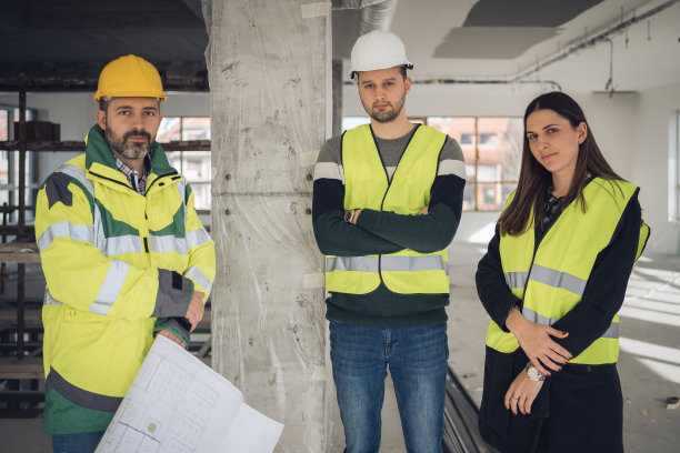 建筑工地上的年轻建筑师和工程师合影图片下载