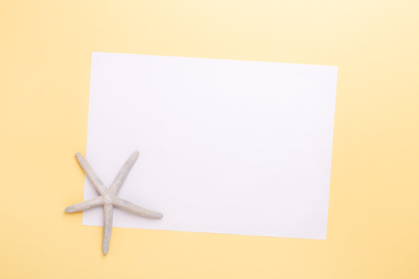黄色背景上的空白纸和海星，夏季假日和假期计划概念图片下载