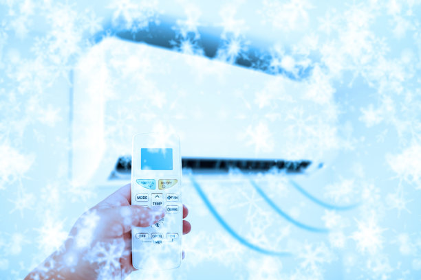 空调冷风吹概念用一个人的手拿着遥控器。图片下载