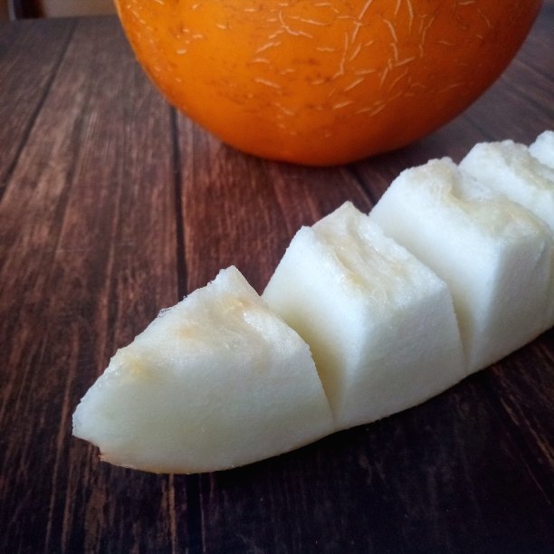 在一张棕色的桌子上，一块多汁的黄色甜瓜图片下载