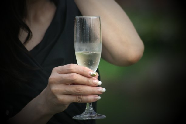 一个拿着高脚杯白葡萄酒的女人的手图片下载