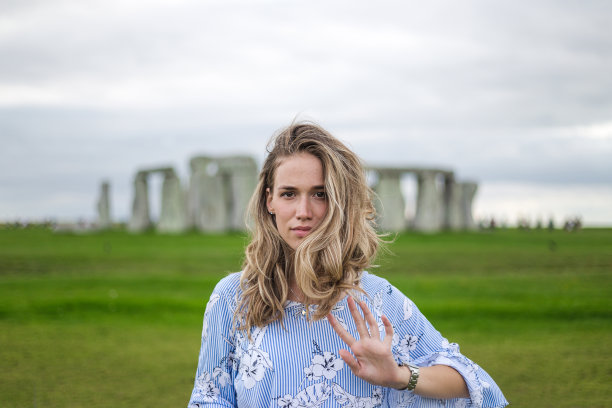 美丽的年轻女子站在巨石阵前图片下载