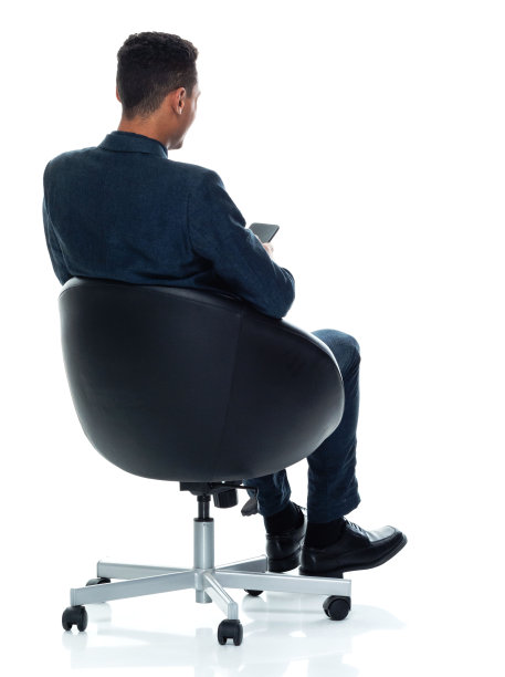 非裔美国人，年轻男性商务人士坐在白色背景下，穿着纽扣衬衫，使用智能手机图片下载