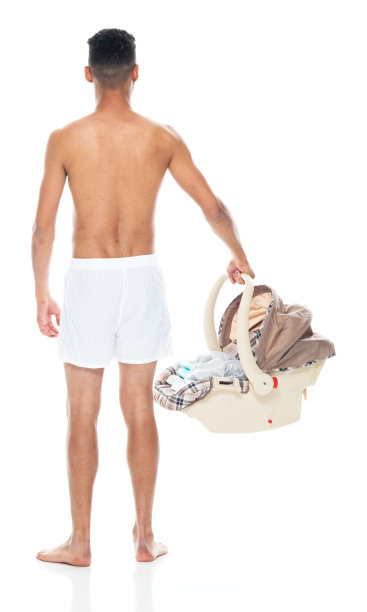 穿着内衣抱着汽车安全座椅站在白色背景前的非裔美国婴儿图片下载