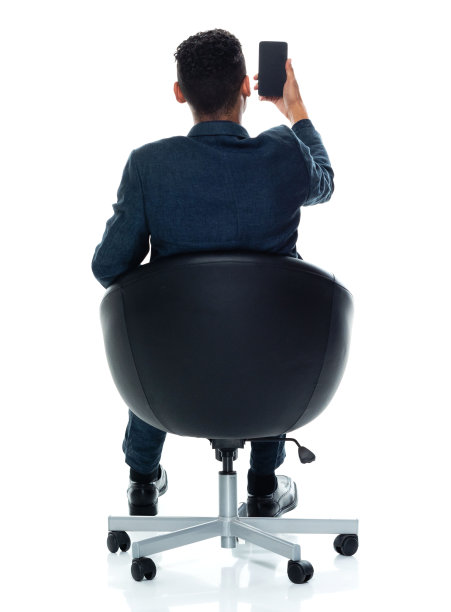 非洲裔男性商人穿着商务休闲装，在白色背景前休息并使用手机图片下载