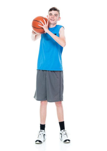 白人男性篮球运动员站在白色背景前，拿着篮球和使用运动球图片下载