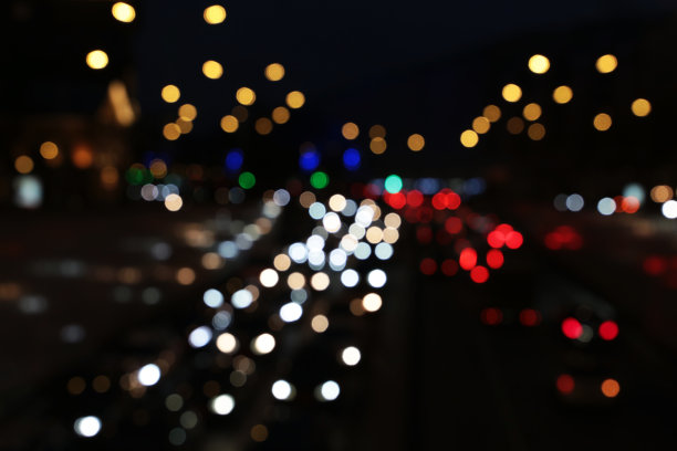 夜晚街道上汽车前灯和灯笼的模糊灯光图片下载