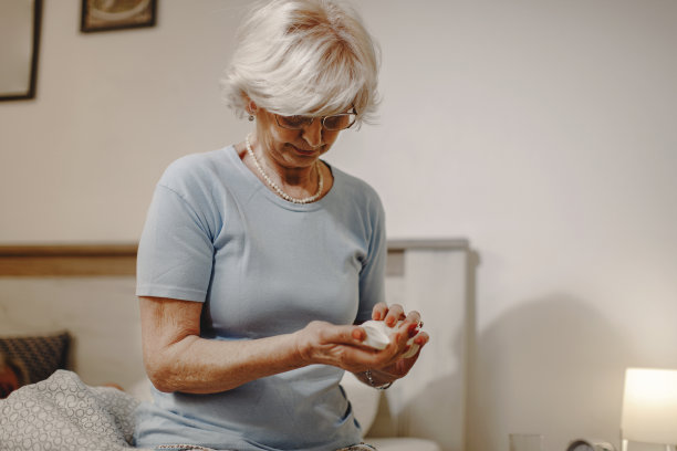 成熟的女人在睡觉前吃药。图片下载