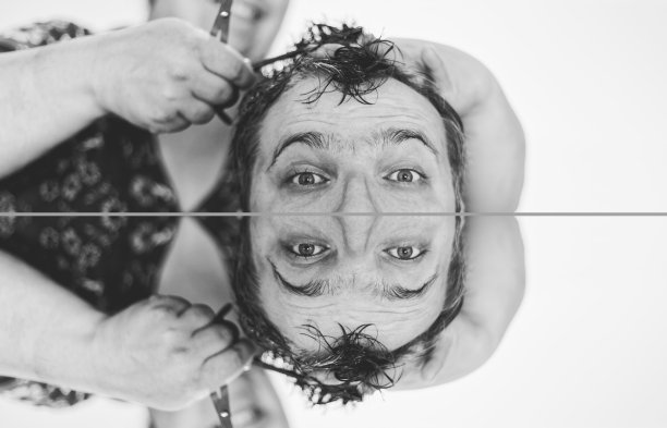 一个年轻人在理发店理发。英俊男子剪影，年轻男子在明亮的灯光下拍摄在工作室摆姿势。美术设计，彩色的男性概念在白色的背景近景去饱和度图片下载