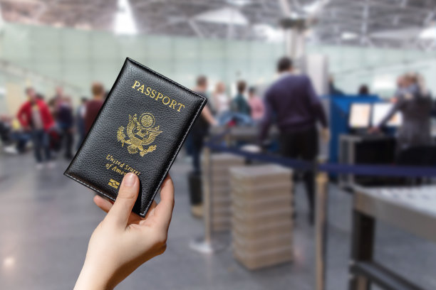 手持美国护照的女子在机场对面接受海关管制或安全服务。的概念。图片下载
