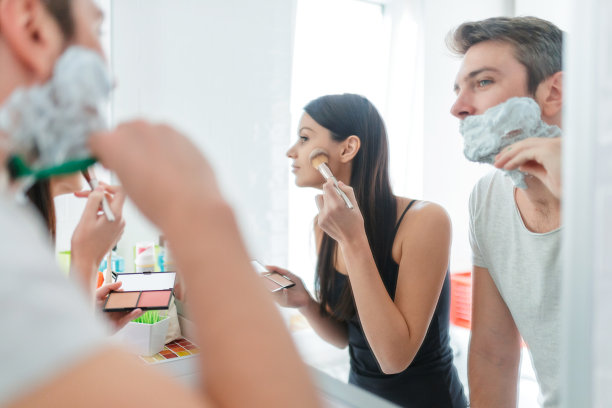 一位年轻女子在镜子前用腮红给丈夫刮胡子图片下载