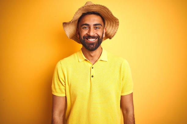 印度青年头戴夏日帽子，面带幸福和酷酷的微笑图片下载