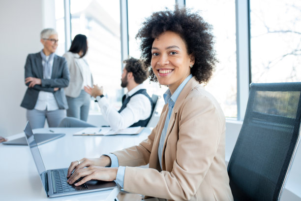 在同事们讨论的时候，一个女人对着镜头骄傲地微笑。图片下载